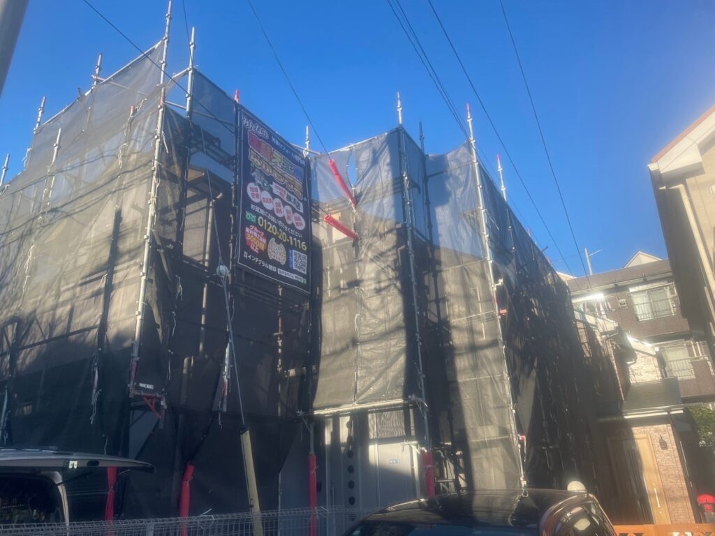 足場架けとメッシュシートを設置します。<br />
メッシュシートを設置することで塗料などが飛散することを防ぎます。