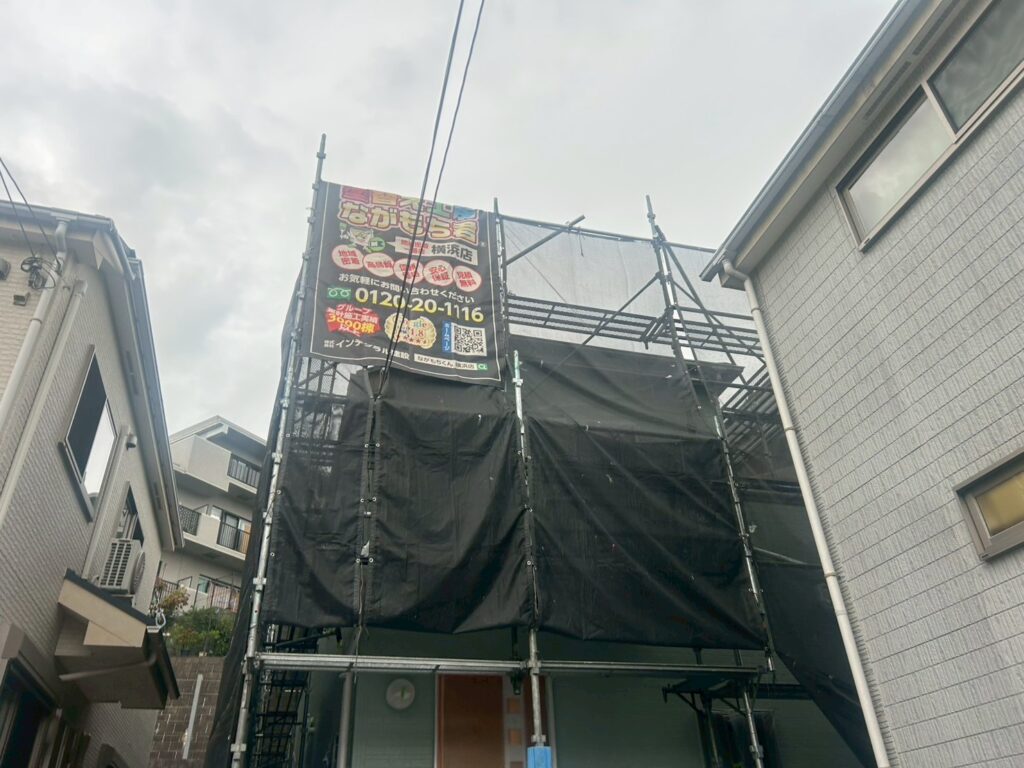 足場架けとメッシュシートを設置します。<br />
メッシュシートを設置することで塗料などが飛散することを防ぎます。