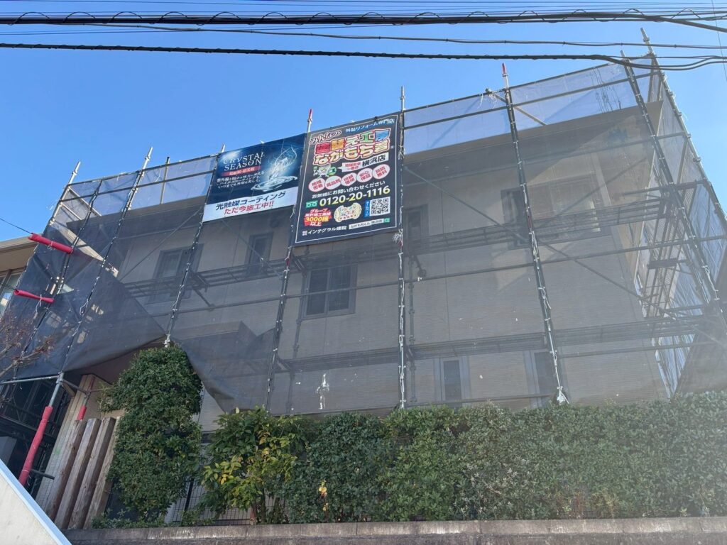 足場架けとメッシュシートを設置します。<br />
メッシュシートを設置することで塗料などが飛散することを防ぎます。