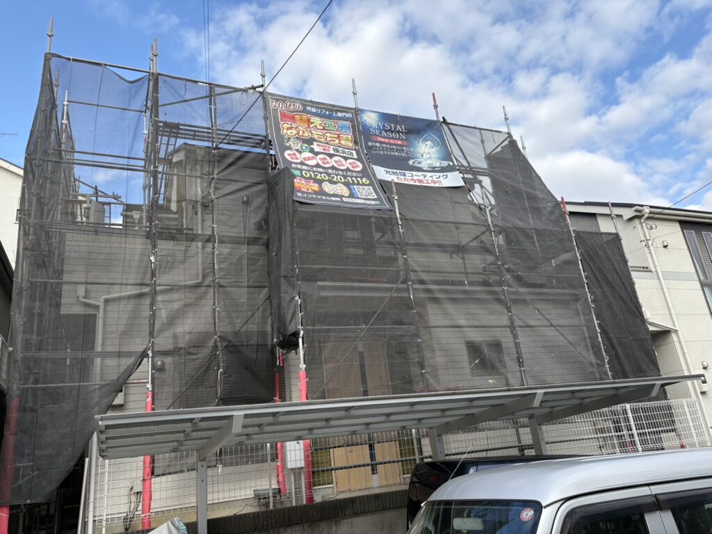 足場架けとメッシュシートを設置します。<br />
メッシュシートを設置することで塗料などが飛散することを防ぎます。