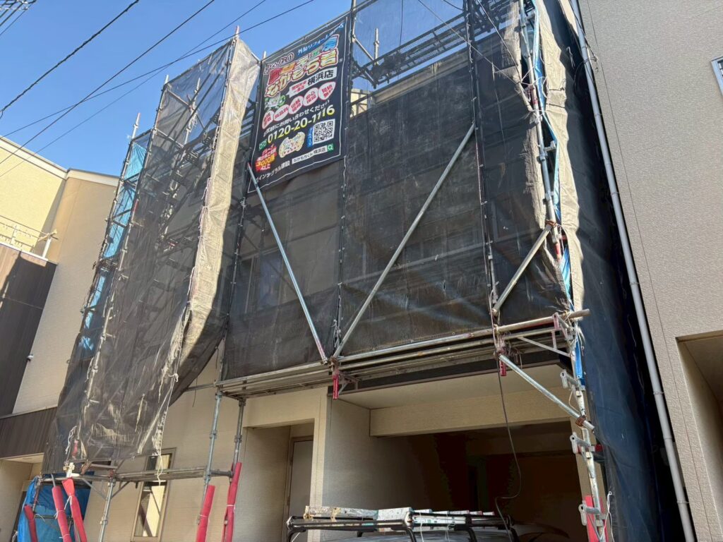 足場架けとメッシュシートを設置します。<br />
メッシュシートを設置することで塗料などが飛散することを防ぎます。